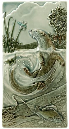 a ceramic tile depicting an otter swimming in the water