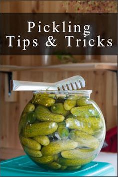 a jar filled with pickles and a toothbrush on top of a blue container