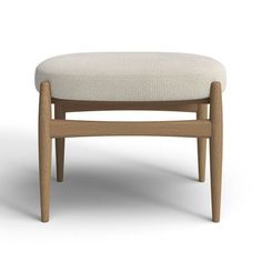 an upholstered stool with wooden legs and a white fabric seat pad on the back