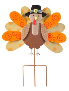 a paper turkey with a black hat on it's head is standing on a metal stand