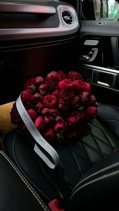 a bunch of red flowers sitting on top of a seat in a car