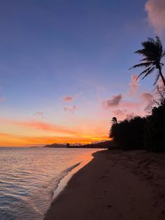 the sun is setting on the beach with palm trees