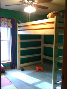 an overhead view of a child's bed and ceiling fan in a room with green walls