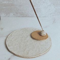 a white and brown object on a table with a wooden stick sticking out of it