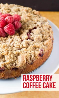 a cake with crumbs and raspberries on top sitting on a plate