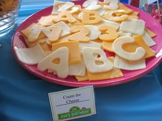 a pink plate topped with cheese and letters