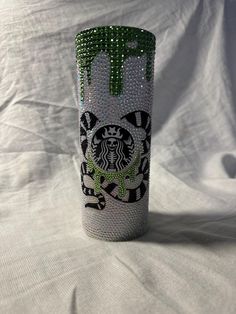 the starbucks cup has been decorated with green and black designs on it's side