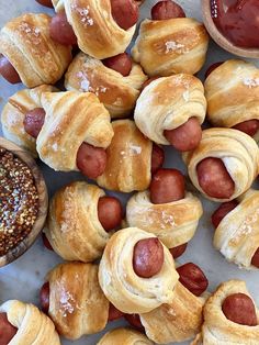 hotdogs wrapped in bread and sprinkled with powdered sugar on a marble surface