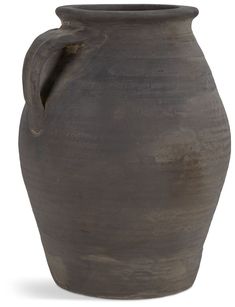 a large brown vase sitting on top of a white table