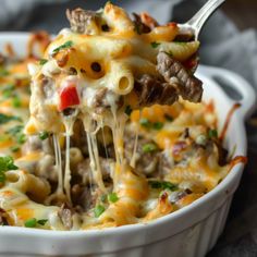 a casserole dish with meat and cheese being lifted from the casserole