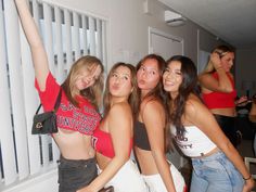 four girls are posing for the camera with their arms in the air