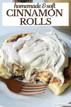 cinnamon rolls with cream cheese frosting on top and a fork in the foreground