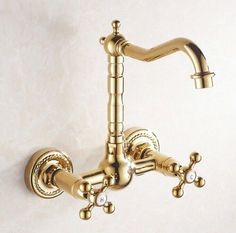 the faucet is attached to the wall and has two spouted handles