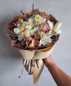 a person holding a bouquet of flowers in their hand