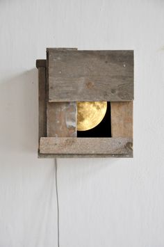 a small window in the side of a wall with a full moon visible through it