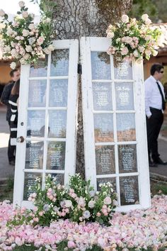 an old window is decorated with flowers and greenery for a wedding ceremony at the park