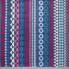 an area rug with different patterns and colors on the ground, including blue, pink, purple