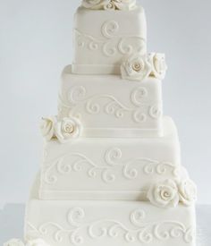 a three tiered white wedding cake with roses on top and the words bridals cake house