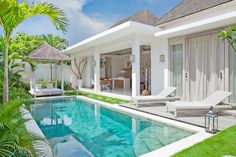 a house with a swimming pool in front of it and two chairs around the pool