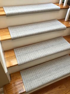 a set of stairs with carpeted treads and wooden handrails in a home