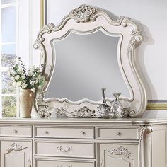 an ornate white dresser and mirror in a room