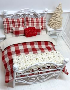 a bed with red and white checkered bedspread next to a christmas tree