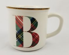 a coffee cup with the letter b painted on it's side and plaid pattern