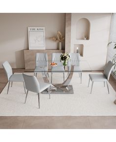 a dining room table with chairs and a rug on the floor in front of it