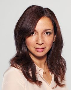 a woman with long brown hair is smiling for the camera