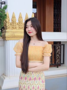 a woman with long hair standing in front of a building