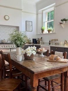 a wooden table sitting in the middle of a kitchen next to an oven and counter top