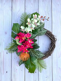 a wreath with flowers and greenery on a white wooden background, ready to be used as a decoration