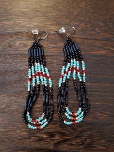 This listing is for these beautiful vintage Native American beaded earrings. Black, turquoise blue, and red colored beads. Condition Like new. Handmade beaded earrings Drop length is almost 2 inches. Width 1 inch. Seed beads Native Inspired Jewelry, Southwestern Dangling Beads For Jewelry Making, Southwestern Blue Beaded Earrings With Round Beads, Traditional Turquoise Beaded Earrings, Traditional Dangle Black Bead Jewelry, Southwestern Style Earrings With Dangling Round Beads, Southwestern Red Beaded Earrings With Dangling Beads, Southwestern Red Beaded Dangling Earrings, Southwestern Red Earrings With Dangling Beads