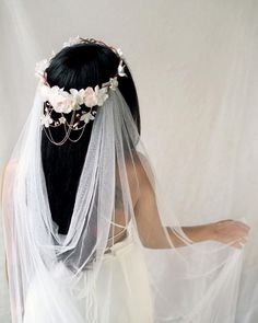 a woman wearing a veil with flowers on it