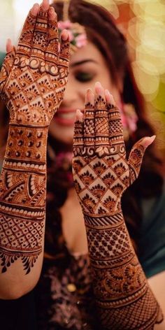 a woman holding her hands up to show the hendi