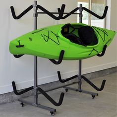 a green kayak sitting on top of a metal stand