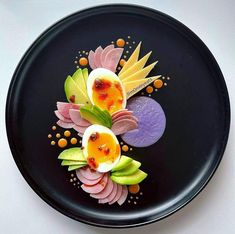 a black plate topped with deviled eggs and flowers