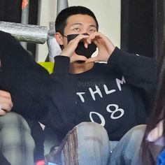 a man sitting on top of a chair holding a cell phone up to his face