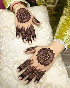 two hands with henna tattoos on them