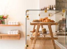 a display case filled with pastries on top of a wooden table