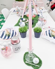 the table is set with pink and blue decorations, plates, cups, and utensils