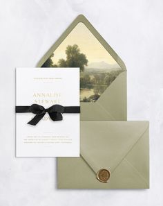 an envelope with a black ribbon and a gold button on the front is next to a card that reads, annice stewart