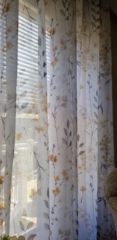 the curtains are closed and ready to be hung in the window sill with flowers on them