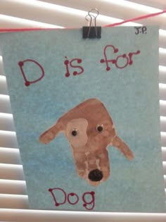 a sign with a dog's face on it hanging from a window sill