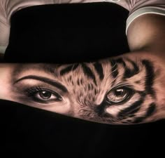 a woman's arm with a tiger face and eyes on her left side, in black and white