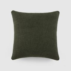 a dark green pillow on a white wall