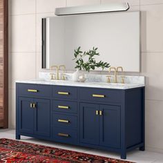 a bathroom vanity with two sinks and gold faucets on the top, along with a rug