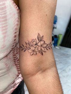 a woman's arm with a flower tattoo on the left side of her arm