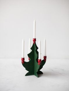 a christmas tree shaped candle holder with white candles