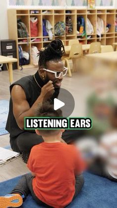 a woman sitting on the floor talking to a little boy who is listening to earbuds